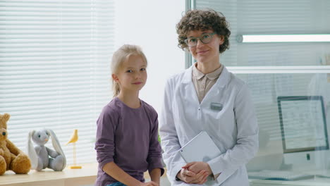 portrait of pretty little girl and female doctor in clinic