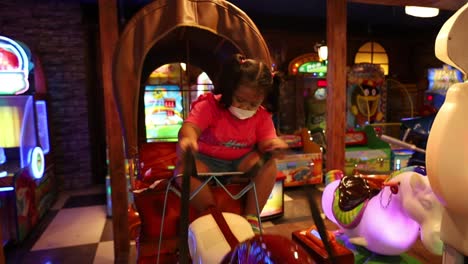 asian little girl playing in the game area or indoor playground