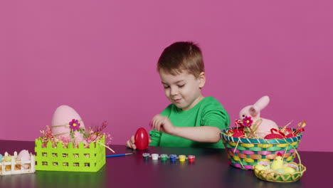 Ecstatic-little-kid-using-watercolor-and-paintbrushes-to-decorate-eggs