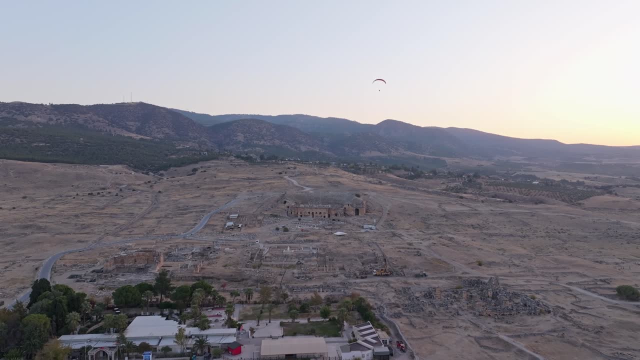 Alba sulle terrazze di Pamukkale con parapendii che volteggiano in alto.