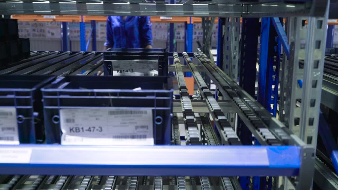 Worker Handling Parts in Automated Warehouse System