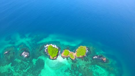 vista a vista de pájaro de tres pequeñas islas cerca de panamá rodeadas de arrecifes de coral y aguas turquesas en américa central