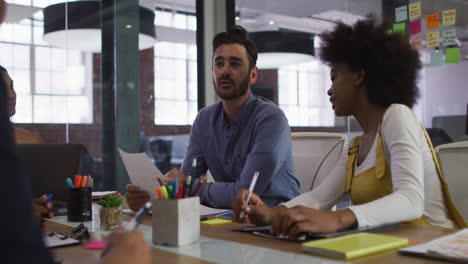 Mixed-race-business-colleagues-sitting-having-a-discussion-in-meeting-room