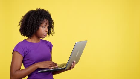 confused woman looking at laptop on yellow background