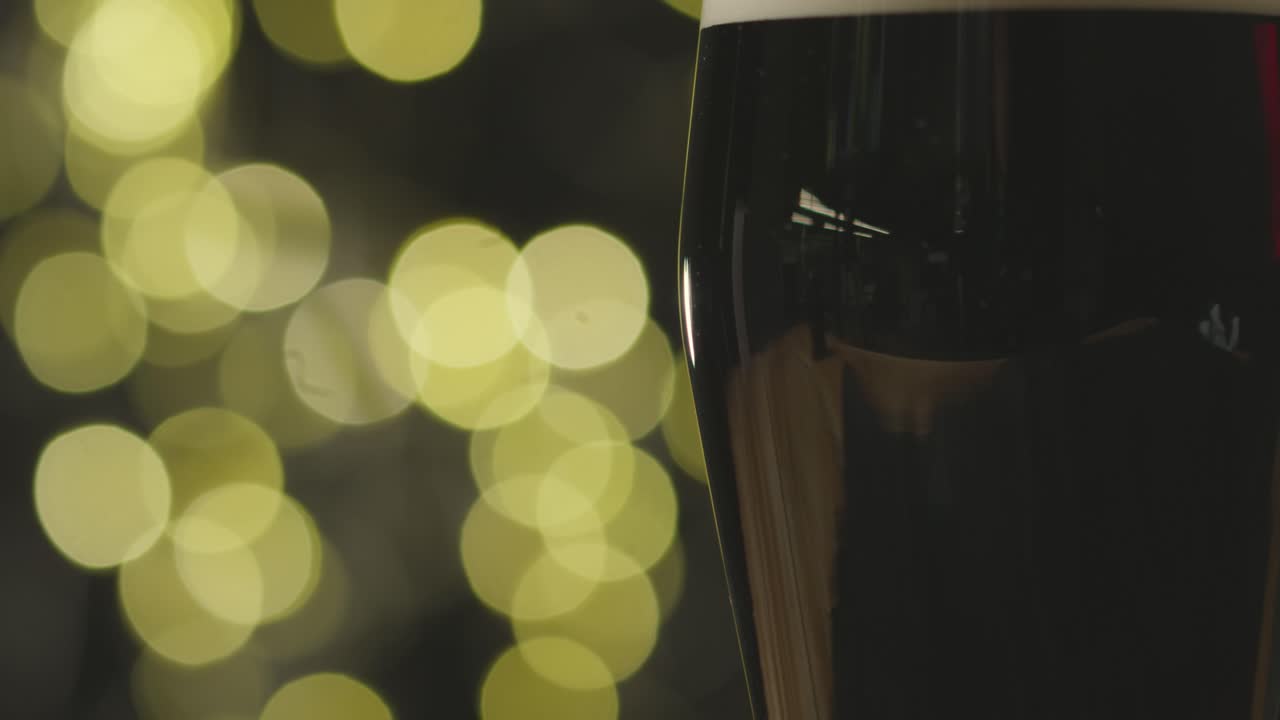 Primo piano di pinta di Irish Stout in bicchiere per celebrare il Giorno di San Patrizio con luci astratte