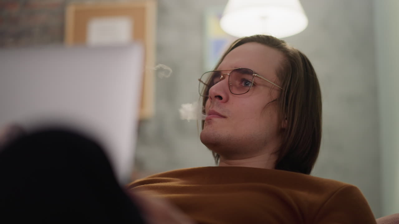 hipster concentrado fuma vape observando el juego de fútbol