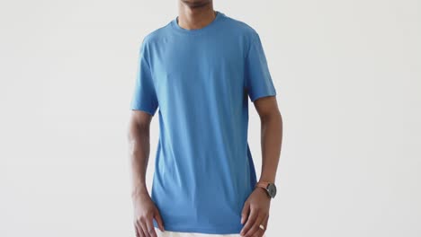 Midsection-of-african-american-man-wearing-blue-t-shirt-with-copy-space-on-white-background