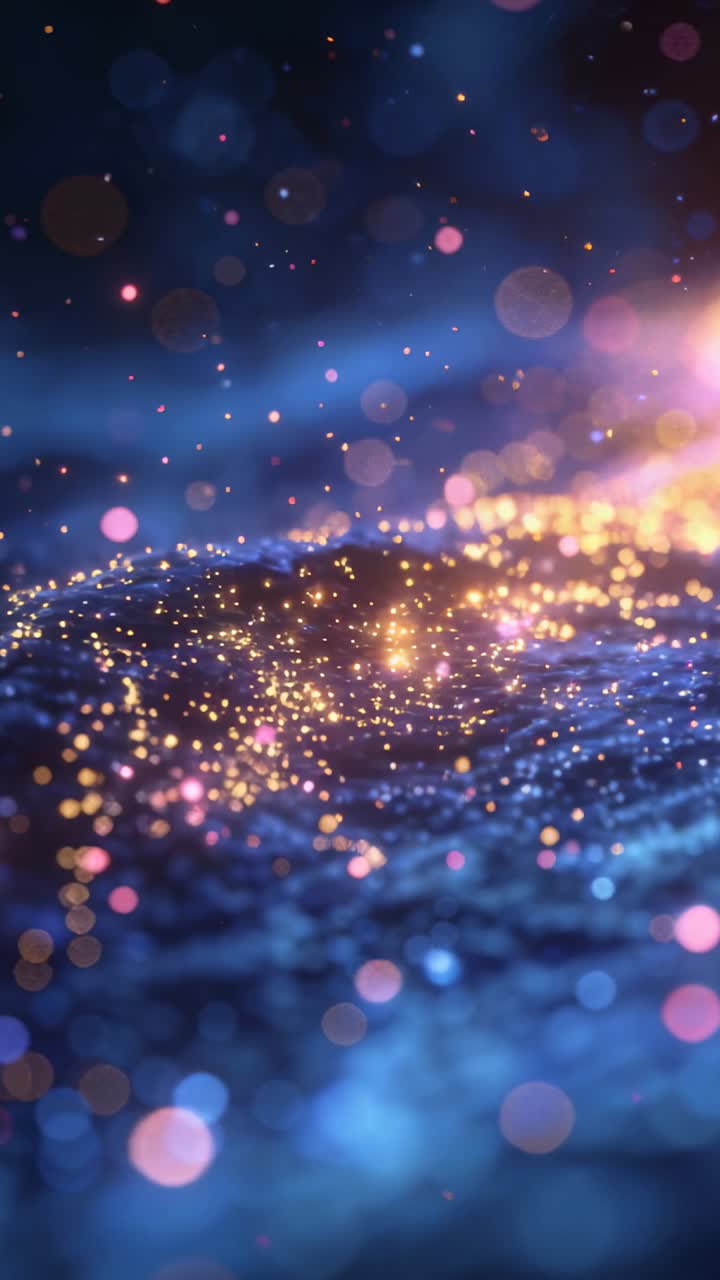 Video verticale: Punti dorati e rosa fluttuano su una superficie blu increspata, con un caldo bagliore a destra che illumina il bokeh.