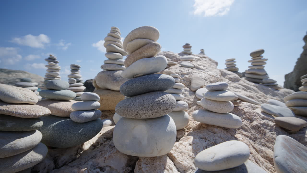 Close up of carefully balanced stones forming cairns on the beach near Aphrodite's Rock