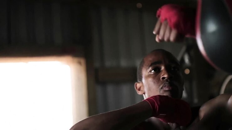 Pugile che colpisce un sacco da boxe in palestra