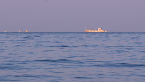 Cargo ship sailing on calm blue sea under evening light