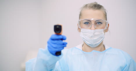 doctor measuring patient temperature at health care clinic