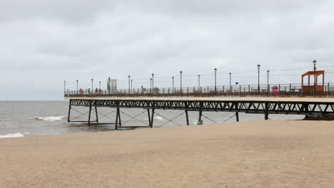 Wide-shot-of-the-pier-on-the-coast-in-the-holiday-town-of-Skegness-on-the-beach-promenade-in-summer