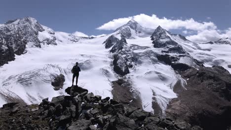 El-Hombre-Está-Mirando-Un-Glaciar-Mientras-El-Dron-Pasa-Volando