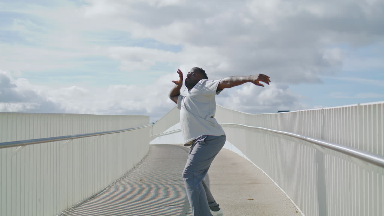 Artista performático em ponte móvel, vista vertical em close-up. Homem ensaiando freestyle.