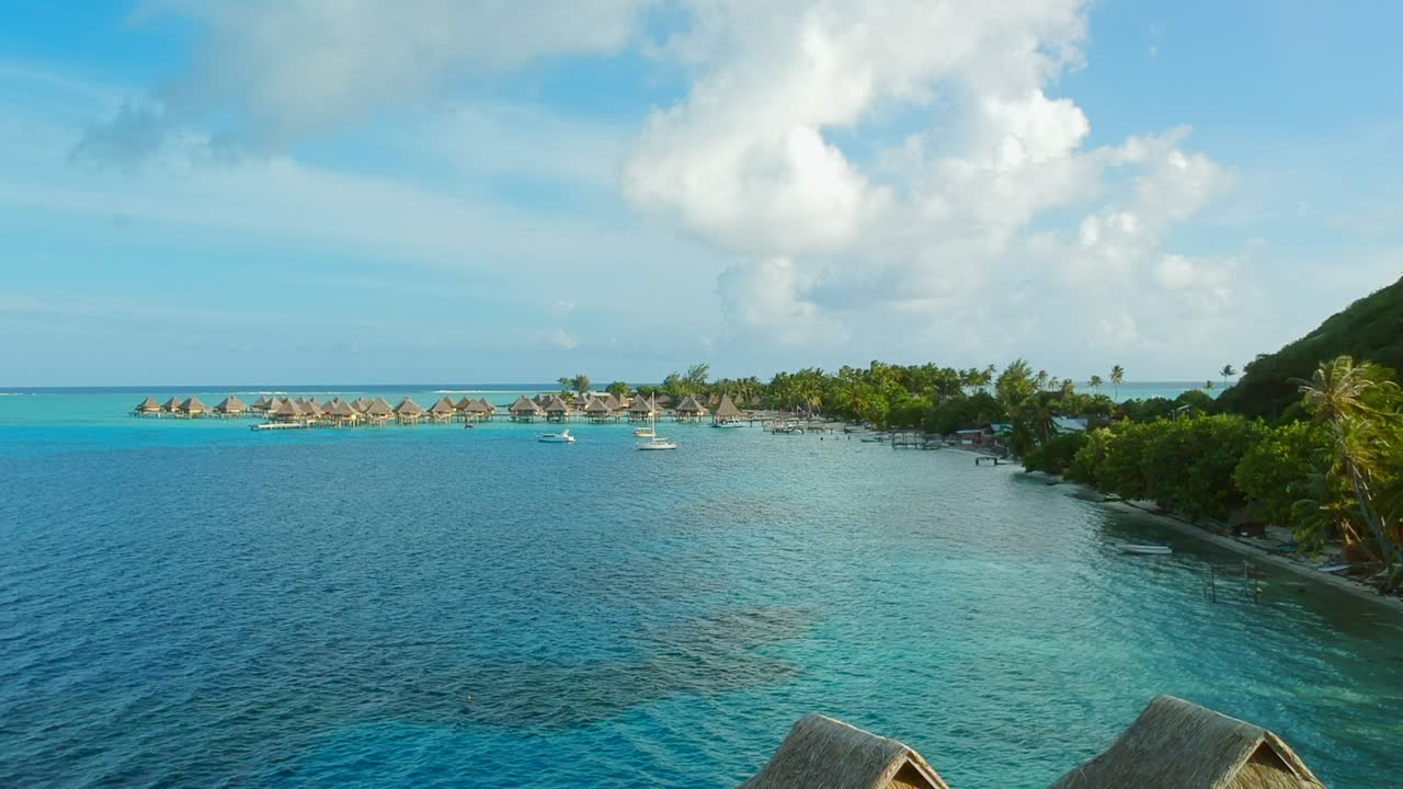 Revealing aerial shot from Overwaterbungalows to a panoramic view of Bora Bora Lagoon, French Polynesia