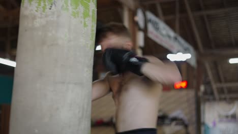 man training with a punching bag in a gym