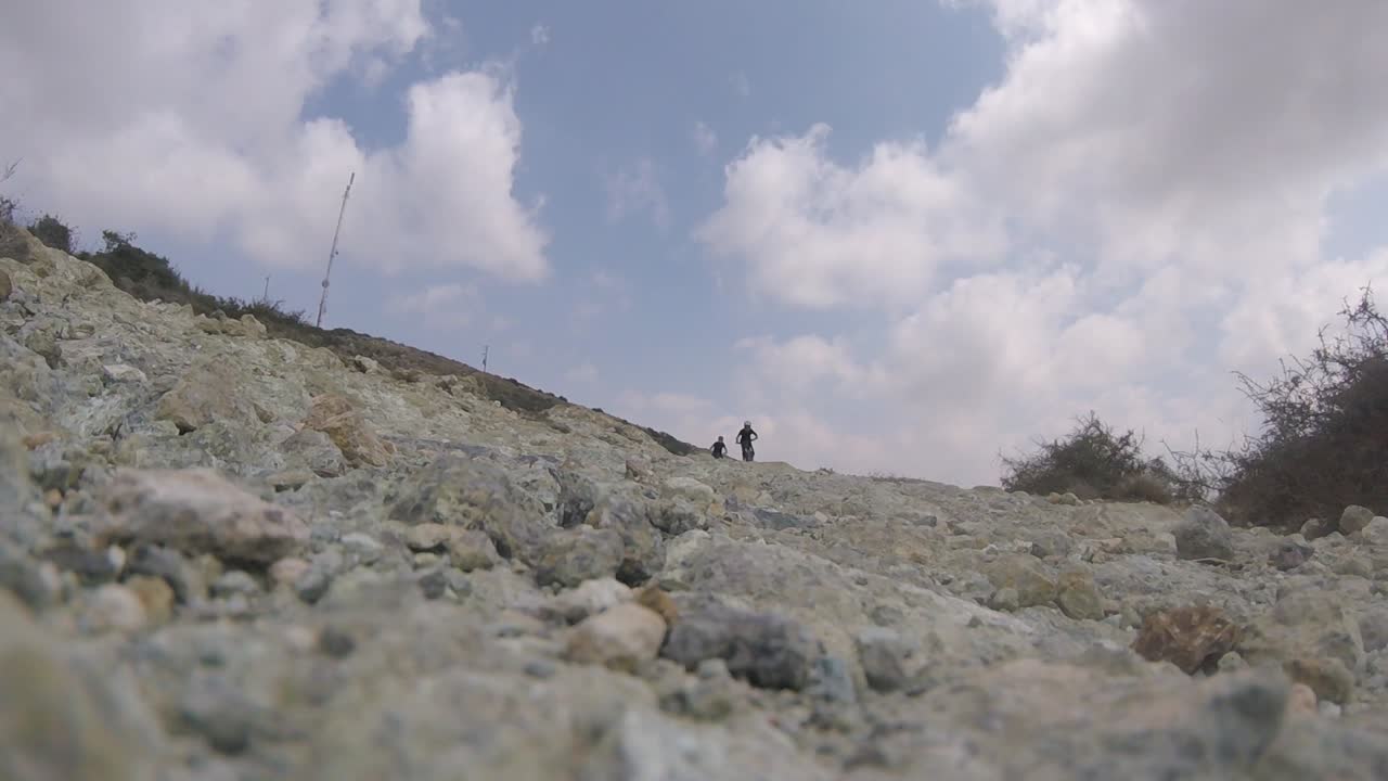 키프로스 아카마스에 있는 바위산에서 카메라를 향해 내리막길을 달리는 산악 자전거 타는 사람들의 낮은 각도