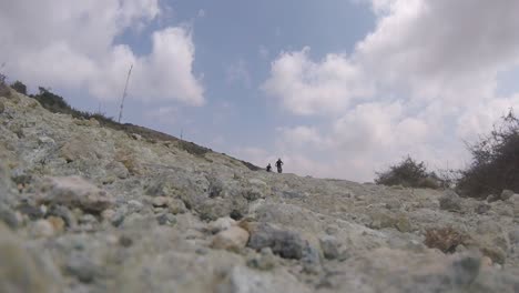 low angle view of mountain bikers riding downhill towards camera on a rocky mountain in akamas, cyprus