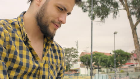 hombre guapo sentado en las escaleras usando una computadora portátil al aire libre