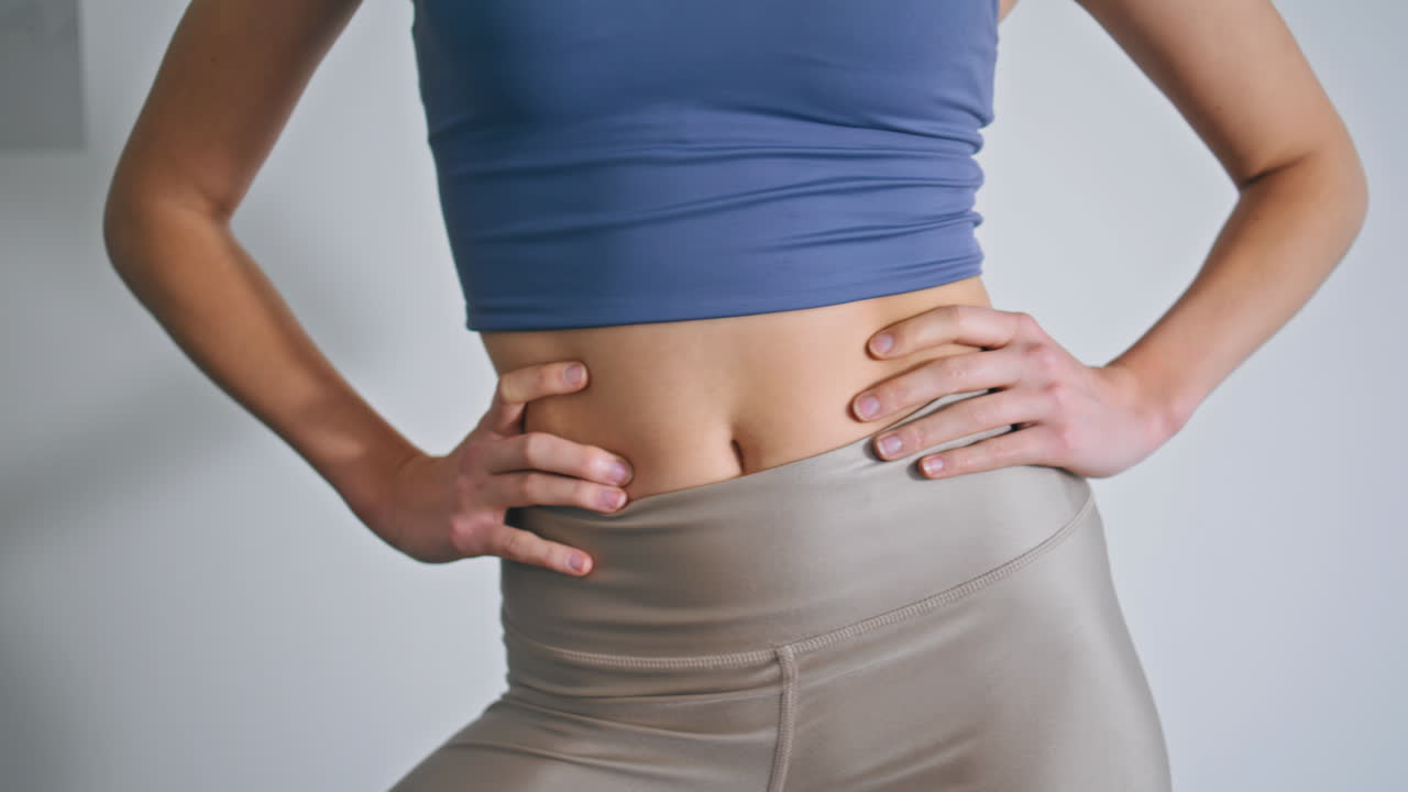 Woman figure training body at white wall closeup. Lady morning workout at home