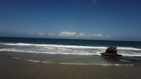 Ein-Bewegter-Zeitraffer-Eines-Strandes-Mit-Felsen-Und-Wolken-Im-Hintergrund