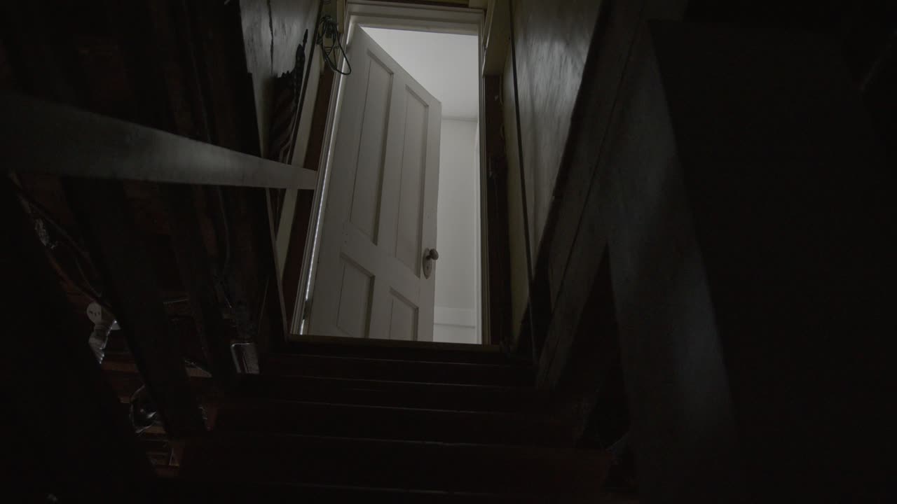 Wide Tilt Up Shot of a Dark and Creepy Basement Staircase