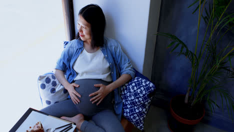 pregnant woman looking through window 4k