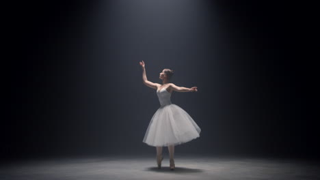 sensual ballerina jumping on stage. ballet dancer dancing pointe shoes indoors.