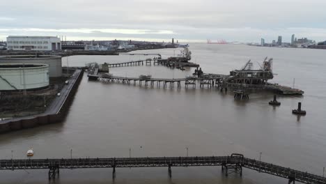 Drohnenblick-Tranmere-Oil-Terminal-Birkenhead-Petrochemische-Hafenverteilung-An-Der-Küste-Steigt-Nach-Vorne-Zu-Pontonkränen