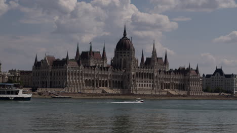 barcos que pasan frente al edificio del parlamento húngaro en budapest a lo largo del danubio