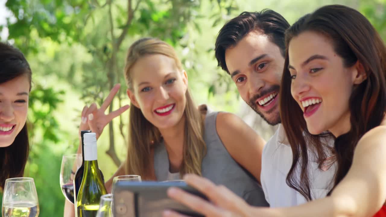grupo de amigos tomando selfies mientras almuerzan