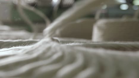 Spools-Of-Yarn-Being-Processed-On-A-Spinning-Machine,-Macro-Shot