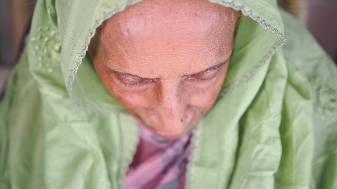 Primo piano di una donna anziana con un foulard verde