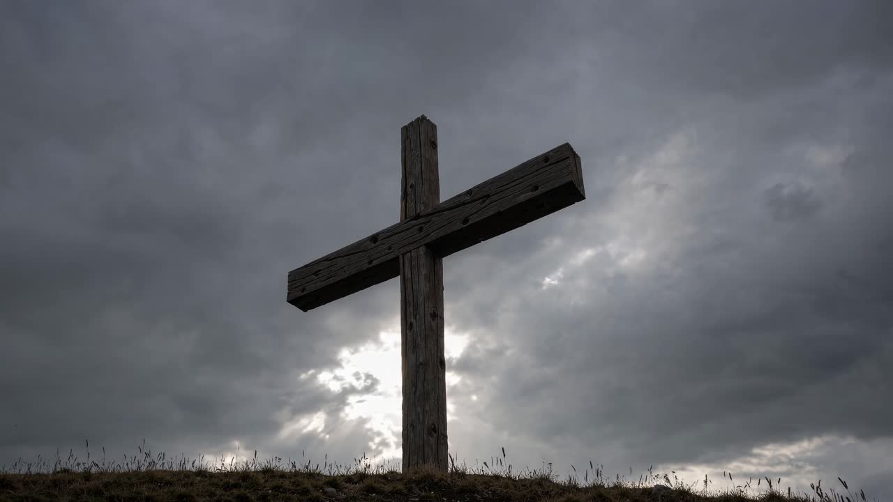 Low-angle shot of a wooden cross against a dramatic cloudy sky, creating a somber and reflective