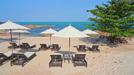 Identische-Sonnenschirme-Und-Strandliegen-Stehen-An-Einem-Weißen-Sandstrand,-Der-Nur-Wenige-Minuten-Leer-Ist,-Bevor-Die-Touristen-Ankommen