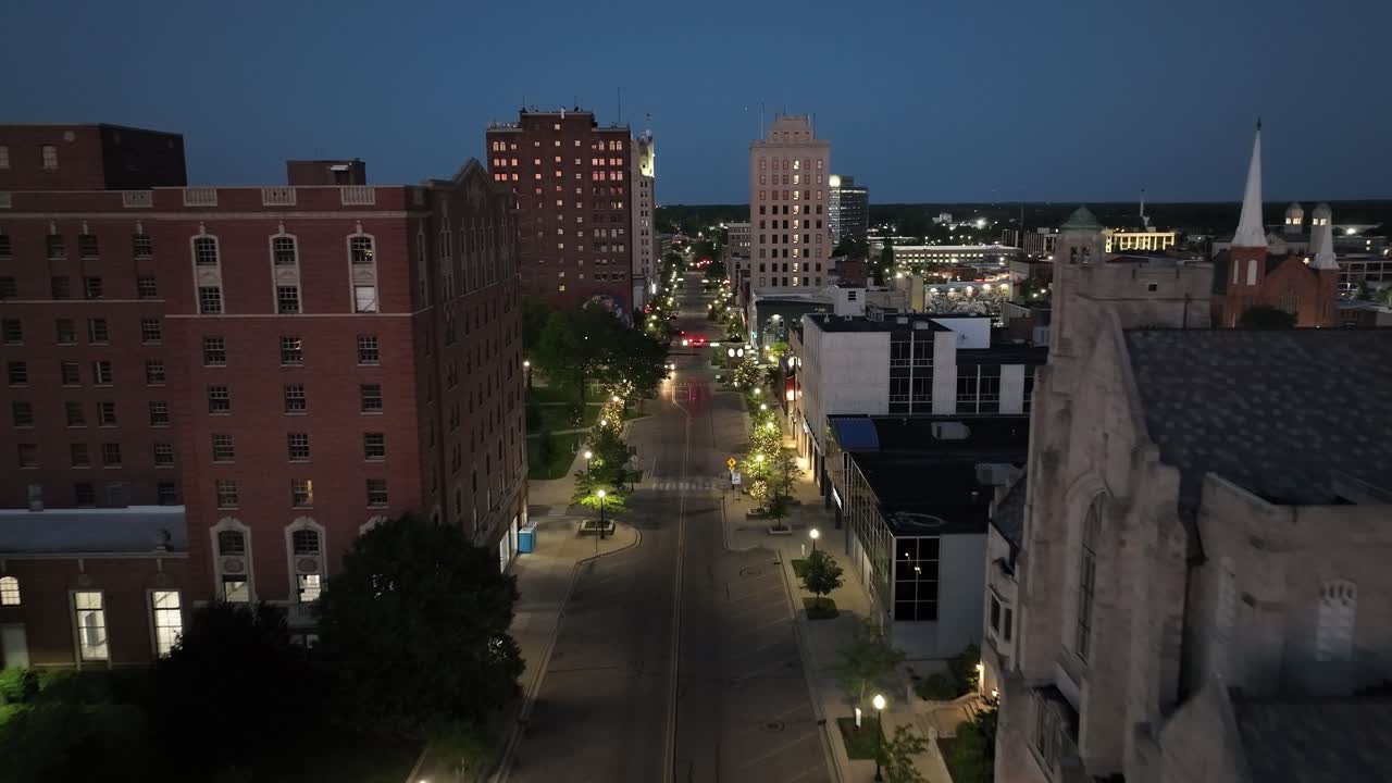 jackson, centro de michigan por la noche con drones video de cerca de los edificios en movimiento hacia adelante