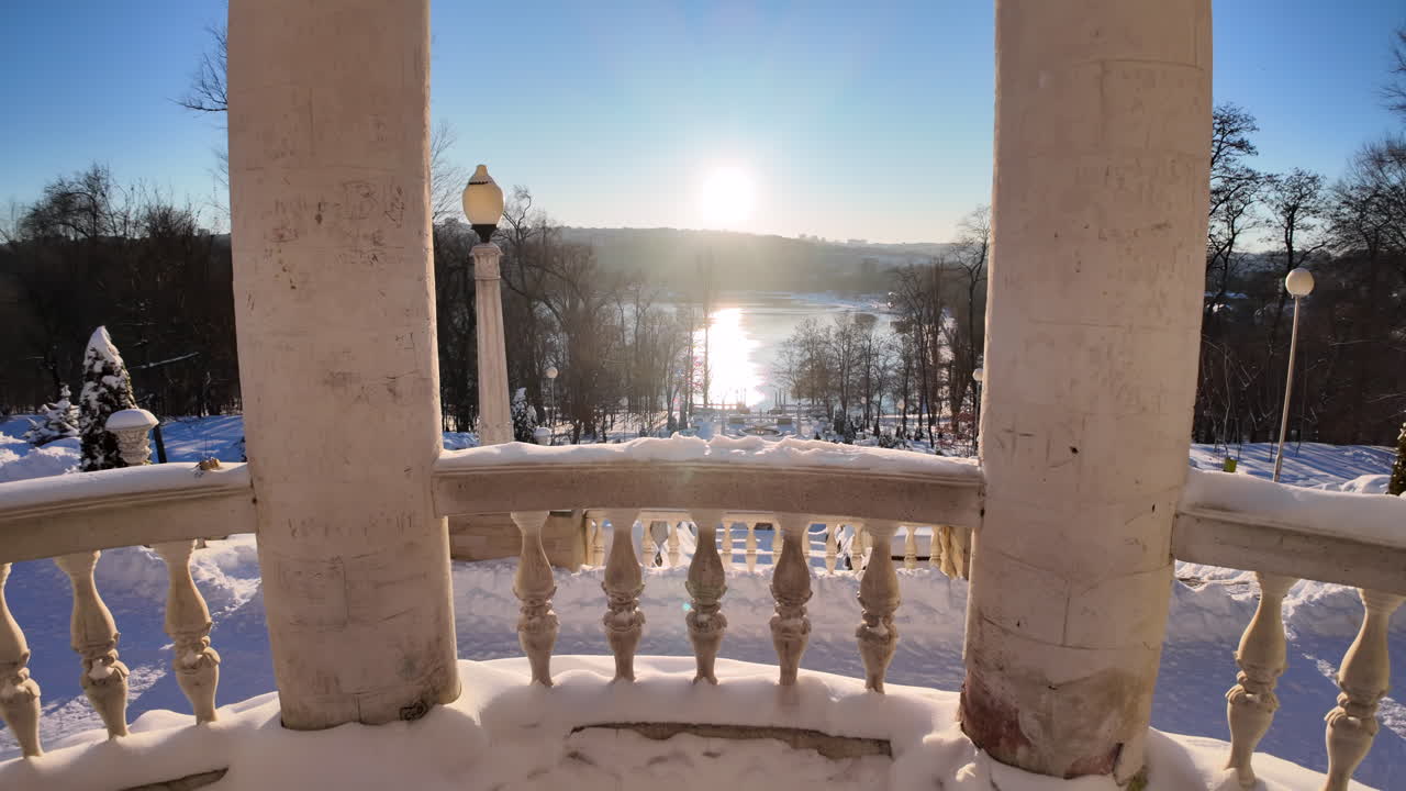 Colonne bianche su un lago ghiacciato con neve bianca in inverno e un sole splendente.
