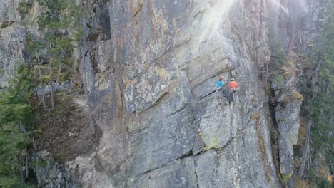 pareja escalando la montaña rocosa 4k
