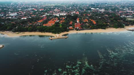 beautiful cinematic sanur beach, bali drone footage with interesting landscape, fishing boats, resorts, hotels and calm weather