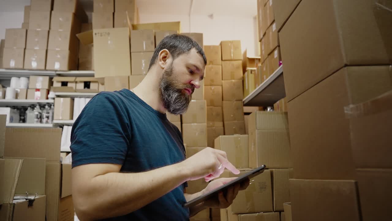 trabajador de almacén comprobando el inventario con una tableta