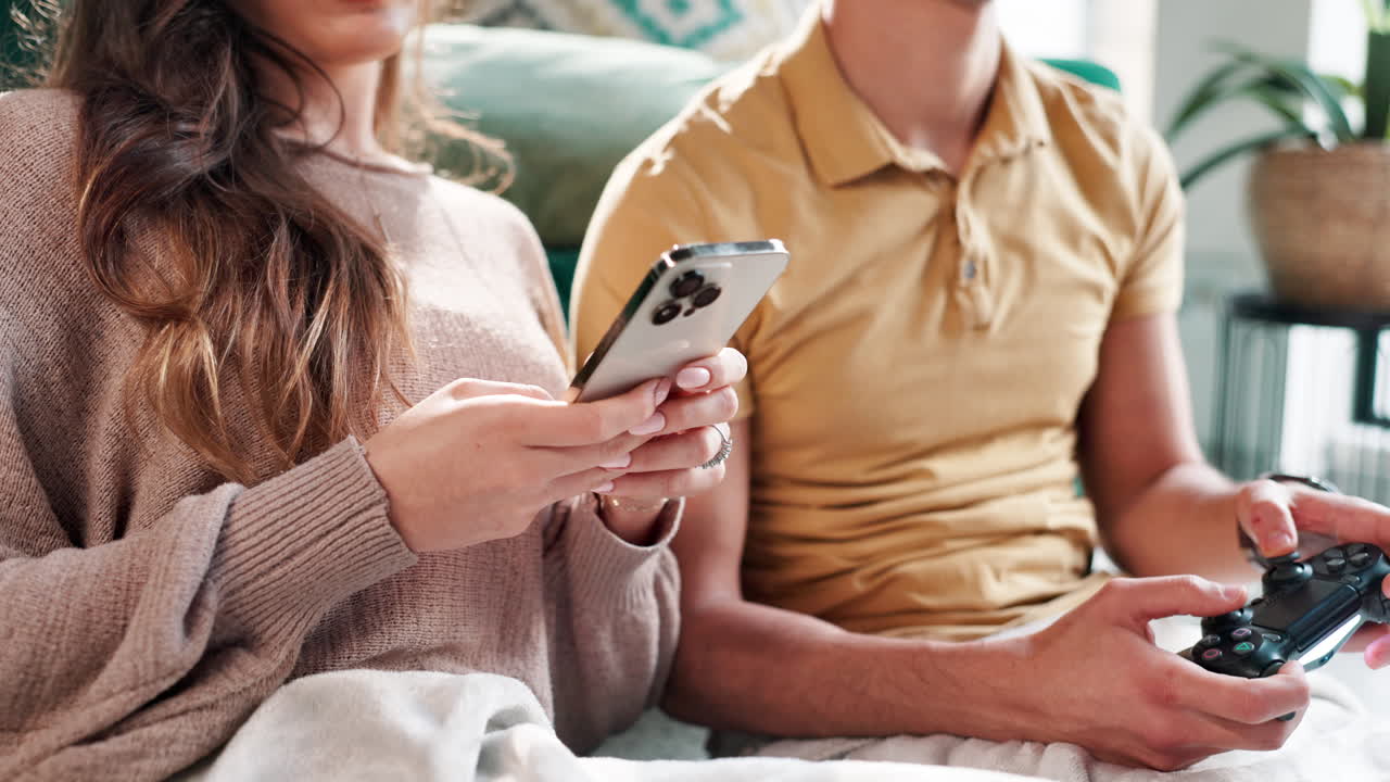 Couple relaxing at home with phone and game