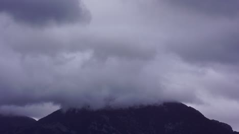 Dark-clouds-covering-high-mountain-at-winter,-fumes-permeate-the-slope