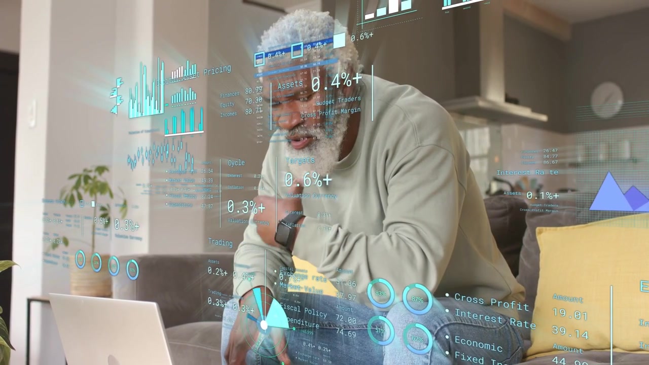 Senior man sitting sofa reading laptop noticing charts tapping phone checking finances via teal HUD