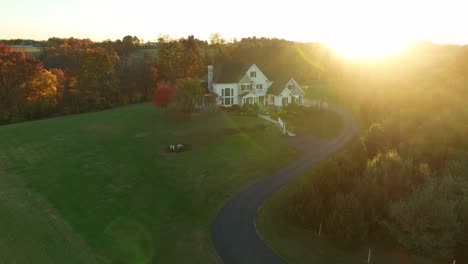 aerial of large modern american home in rural countryside at autumn sunset