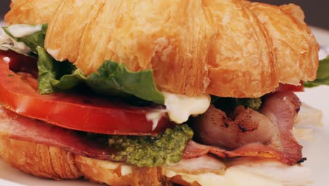 croissant with jamon ham, salmon, in modern cafe, top view of healthy breakfast in cafe. english breakfast: fried egg, bacon toast on sandwich.