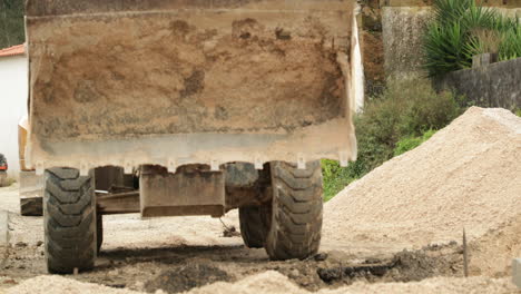 excavator at work unloading sand on road construction site in leiria, portugal