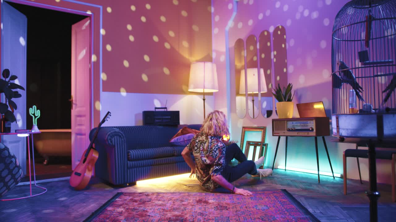 브레이크 댄스를 추려고 노력하고 집에 있는 빈티지 거실에서 바닥에 쓰러지는 세련된 백인 젊은이