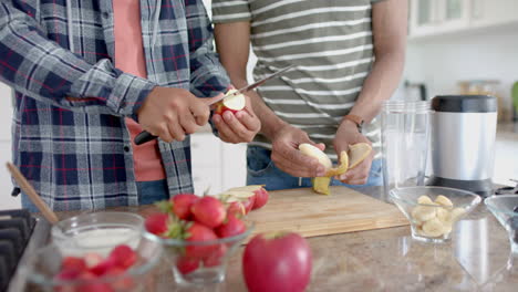 Glückliches,-Heterosexuelles-Paar,-Das-In-Der-Küche-Obst-Für-Einen-Gesunden-Smoothie-Zubereitet,-Zeitlupe