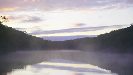 Niebla-Que-Se-Eleva-Desde-Un-Lago-Tranquilo-Por-La-Mañana